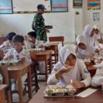 Anggota Babinsa Koramil 0110/Labuan Kodim 0601/Pandeglang Dampingi Program Makan Bergizi Gratis di Sekolah